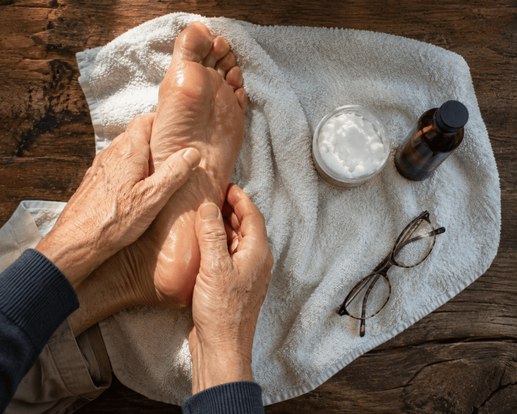 Senior man applying coconut oil to foot sole as diabetic natural remedy
