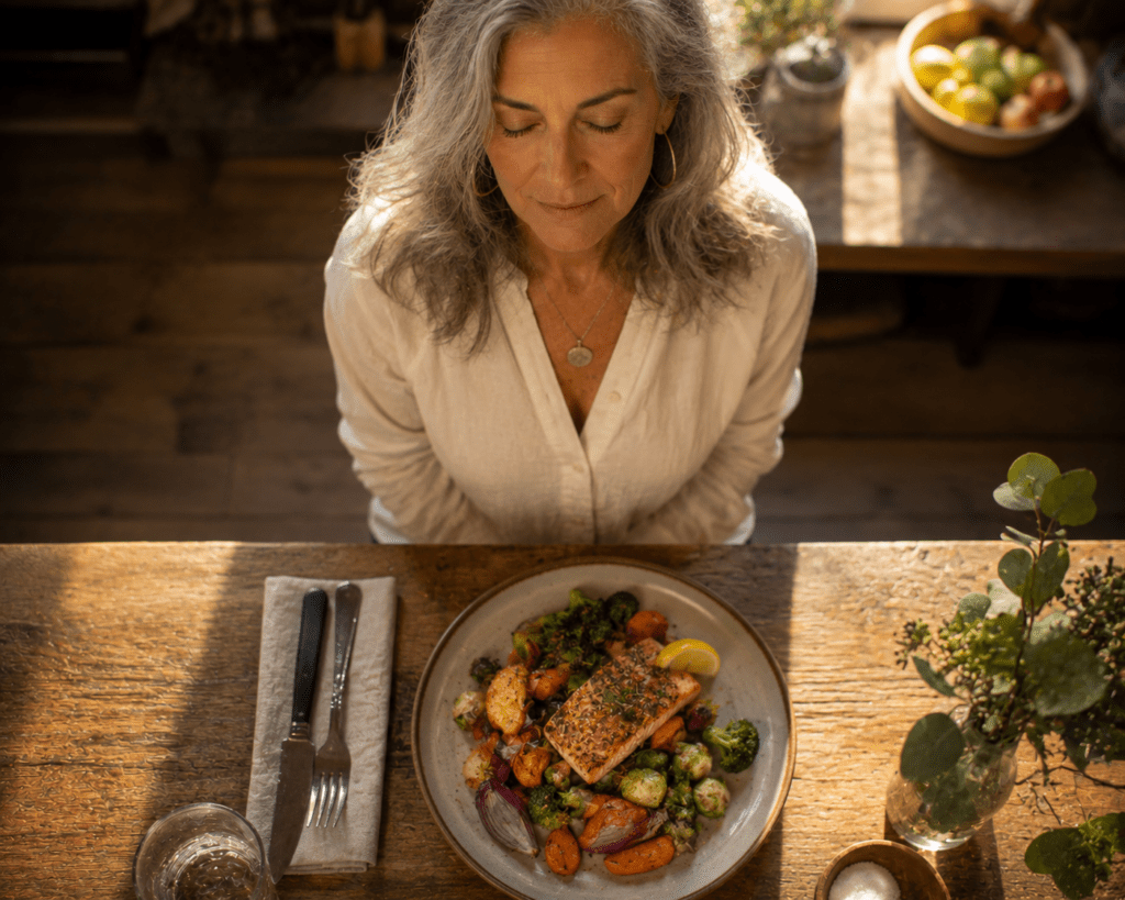 Woman over 60 pausing mindfully before a nutritious meal at home