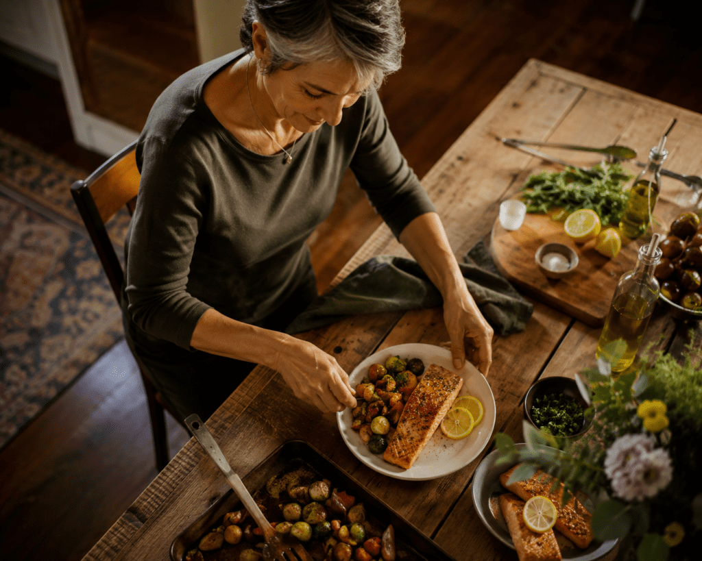 Woman in her late 50s serving omega-3 rich salmon dinner for joint health benefits
