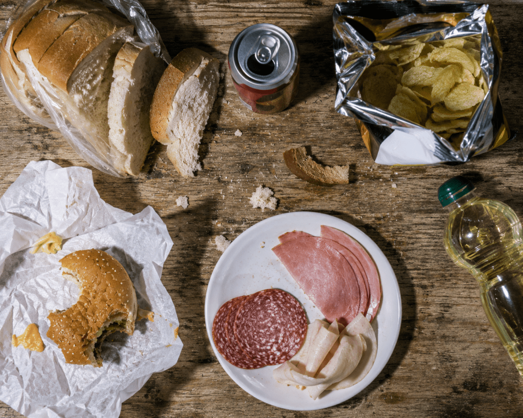 Overhead view of common inflammatory foods including white bread and processed meats